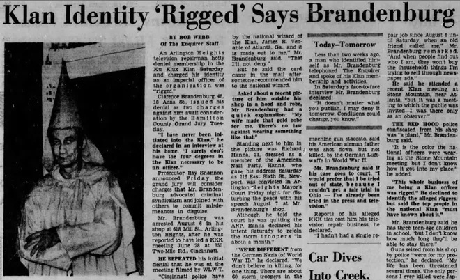 Black-and-white newspaper clipping from the Cincinnati Enquirer, dated September 20, 1964, showing Clarence Brandenburg wearing a white Klan robe and pointy hood. Headline reads “Klan Identity ‘Rigged’ Says Brandenburg.” Article covers Brandenburg’s arrest after a KKK rally, during which he denied being a Klansman, despite photographic evidence to the contrary.